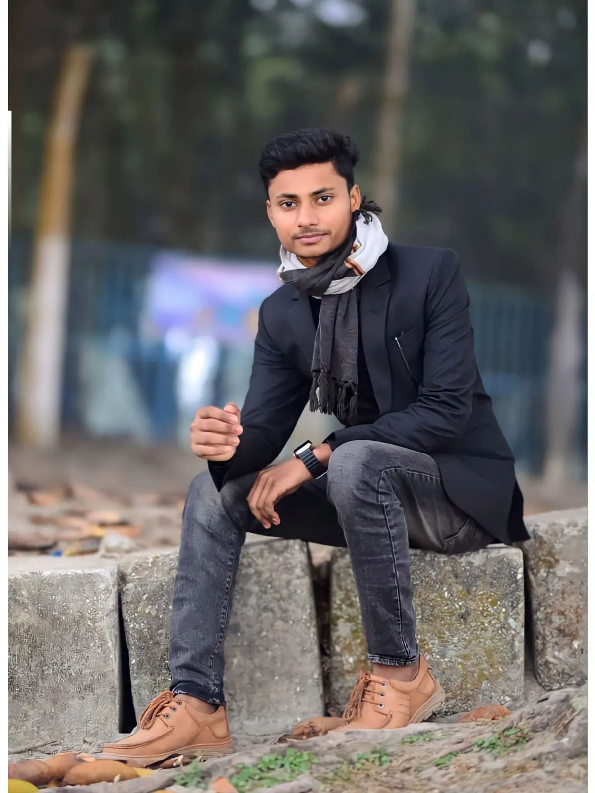 Awshan Hossain wearing a dark blazer and scarf outdoors